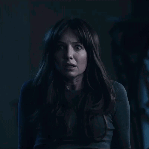 A Woman With Long Hair Is Looking At The Camera With A Shocked Look On Her Face GIF