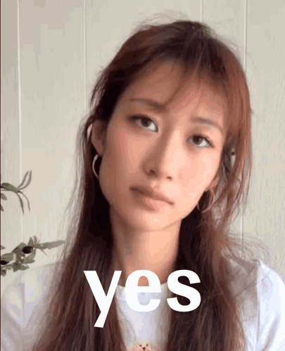 A Woman With Long Hair Is Looking At The Camera With The Word Yes In Front Of Her GIF