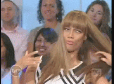 A Woman With Long Hair Is Making A Funny Face In Front Of A Group Of People With A Tnt Logo In The Corner GIF
