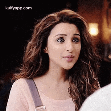 A Woman With Long Hair Is Making A Funny Face While Looking At A Man . GIF