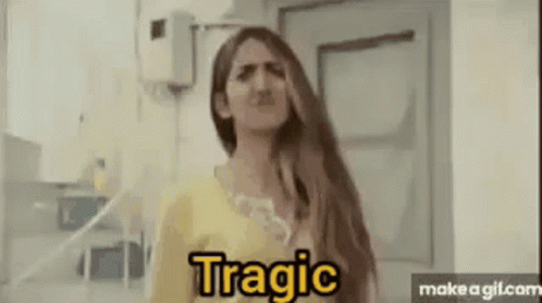 A Woman With Long Hair Is Making A Funny Face While Standing In Front Of A Door . GIF
