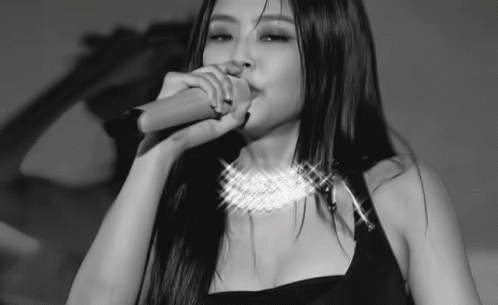 A Woman With Long Hair Is Singing Into A Microphone . GIF