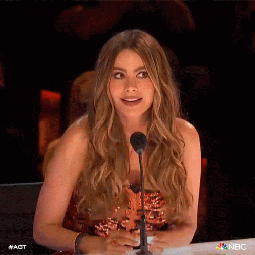 A Woman With Long Hair Is Sitting In Front Of A Microphone . GIF