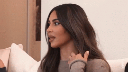 A Woman With Long Hair Is Sitting On A Couch And Talking To Another Woman . GIF