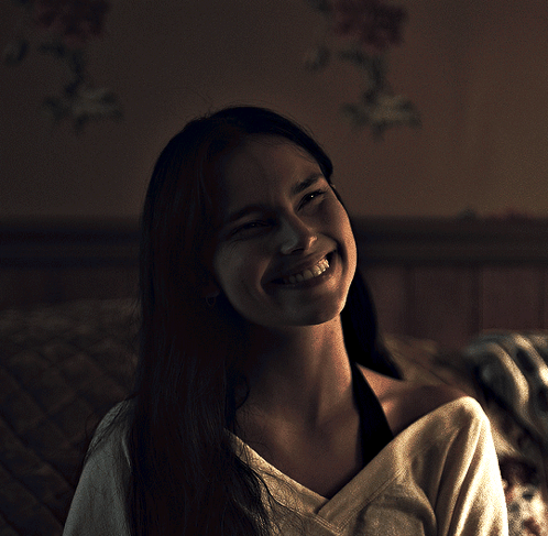 A Woman With Long Hair Is Smiling And Looking Up At The Camera GIF