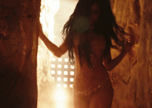 A Woman With Long Hair Is Standing In Front Of A Wall With Squares On It GIF