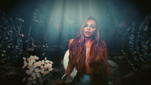 A Woman With Long Hair Is Standing In The Dark GIF