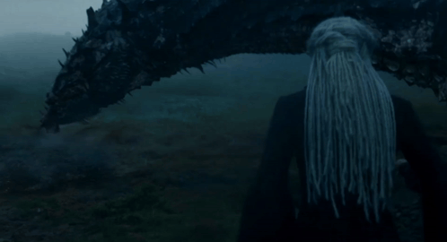 a woman with long hair is standing next to a large dragon
