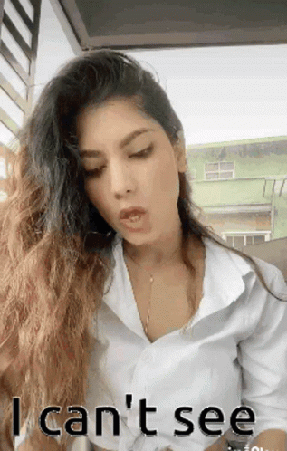 A Woman With Long Hair Is Wearing A White Shirt And Says I Can T See GIF
