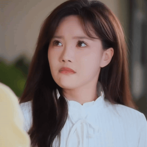 A Woman With Long Hair Is Wearing A White Shirt GIF