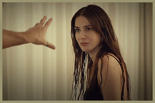 A Woman With Long Hair Looks At A Man 'S Hand Reaching Out GIF