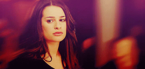 A Woman With Long Hair Looks At The Camera With A Purple Background GIF