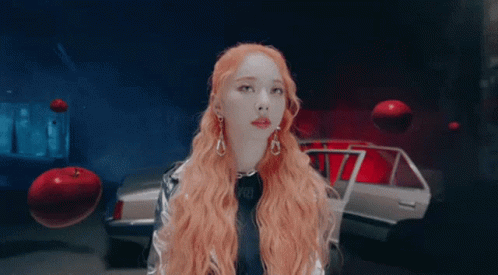 Woman With Long Red Hair In Front Of Silver Car GIF