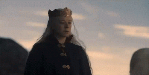 A Woman With Long White Hair Is Wearing A Crown And A Black Coat . GIF