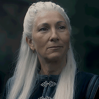 A Woman With Long White Hair Is Wearing Earrings And A Black Jacket GIF