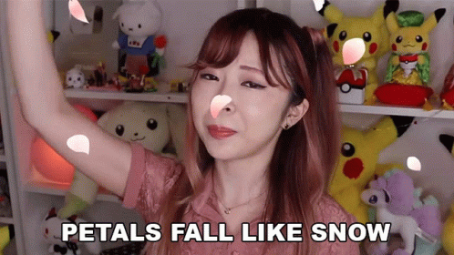 A Woman With Petals Falling On Her Face And The Words Petals Fall Like Snow GIF