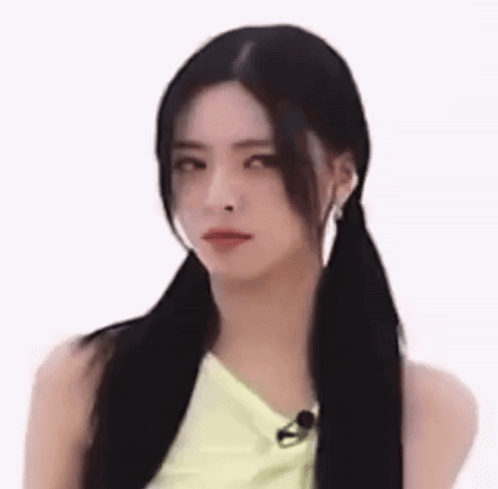 A Woman With Pigtails Is Making A Funny Face While Wearing A Yellow Top . GIF