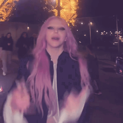 a woman with pink hair and a black jacket