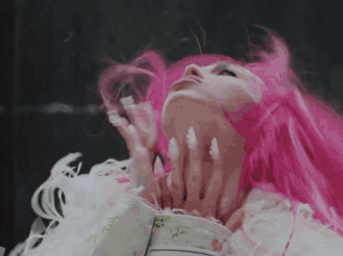 a woman with pink hair and white nails