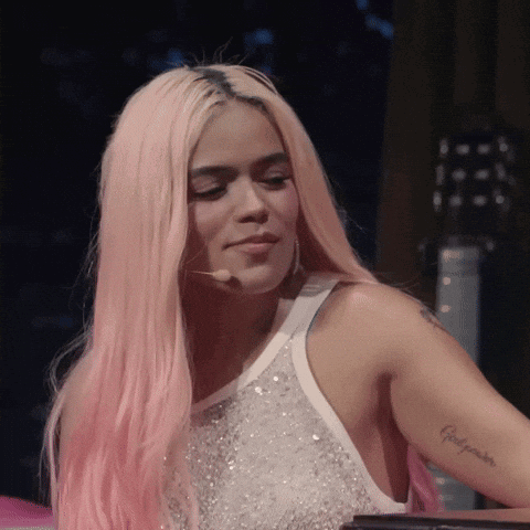 A Woman With Pink Hair Has A Tattoo On Her Arm That Says ' Felicidades ' GIF