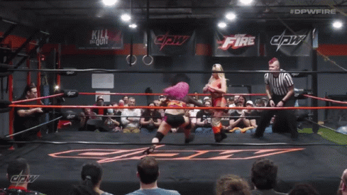 A Woman With Pink Hair Is In A Wrestling Ring With #Dpwfire Written Above Her GIF