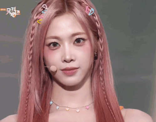 A Woman With Pink Hair Is Making A Face With Her Hands On Her Face . GIF