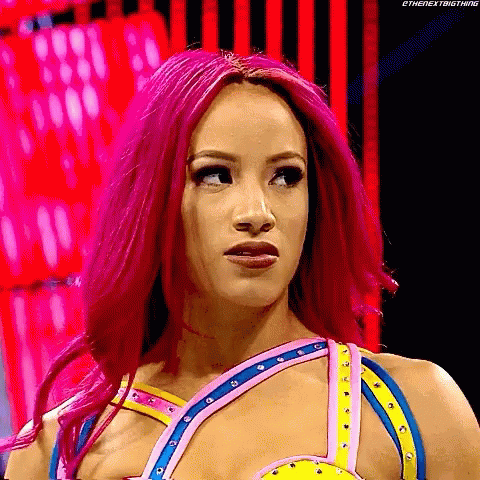 A Woman With Pink Hair Is Standing In Front Of A Red Background . GIF