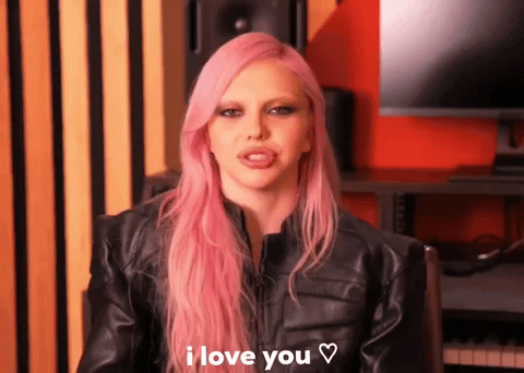 a woman with pink hair is wearing a black leather jacket and says i love you