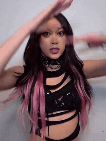 A Woman With Pink Hair Is Wearing A Black Top And Choker GIF