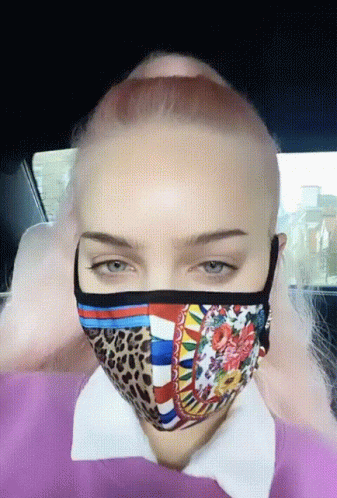 A Woman With Pink Hair Is Wearing A Mask GIF