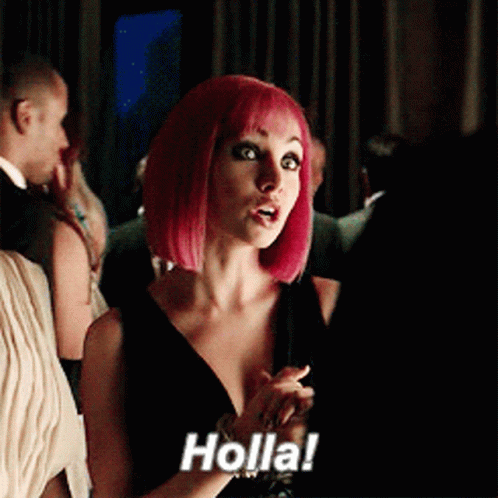 A Woman With Pink Hair Says Holla In A Crowded Room GIF