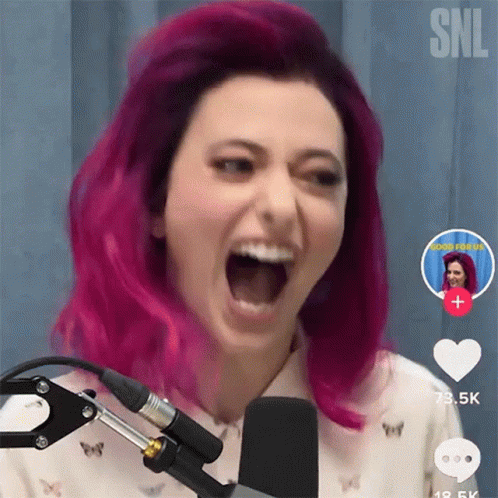 A Woman With Pink Hair Screaming Into A Microphone GIF