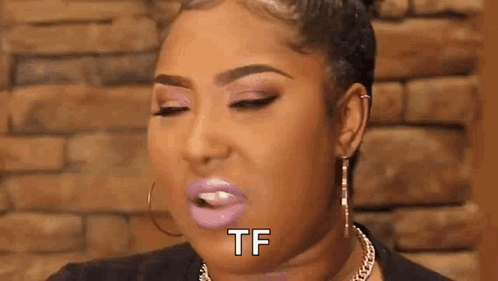A Woman With Pink Lipstick And Earrings Is Making A Funny Face And Saying `` Tf '' . GIF