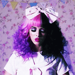 A Woman With Purple And Black Hair Has A Pink Bow On Her Head GIF