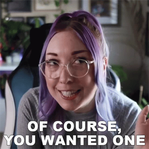A Woman With Purple Hair And Glasses Is Smiling With The Words Of Course You Wanted One Below Her GIF