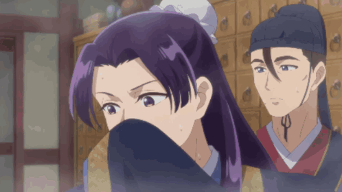 A Woman With Purple Hair Is Covering Her Face While A Man Looks On GIF