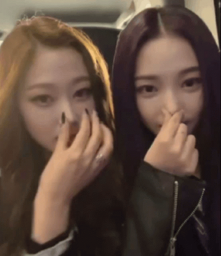 A Woman With Purple Hair Is Covering Her Nose With Her Hand GIF