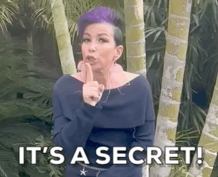 A Woman With Purple Hair Is Holding Her Finger To Her Lips And Says `` It 'S A Secret '' . GIF