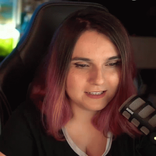 A Woman With Purple Hair Is Sitting In Front Of A Rode Microphone . GIF