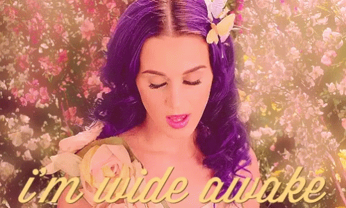 a woman with purple hair is surrounded by flowers and the words " i 'm wide awake " are on the bottom