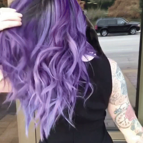 A Woman With Purple Hair Is Wearing A Black Top GIF