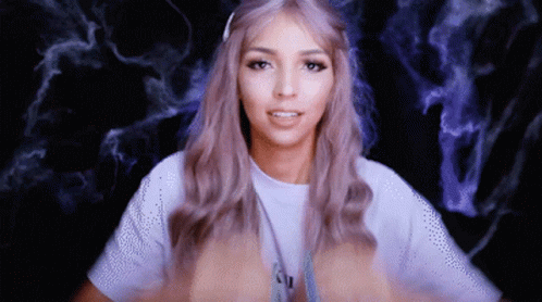 A Woman With Purple Hair Is Wearing A White T-Shirt With The Letter N On It GIF