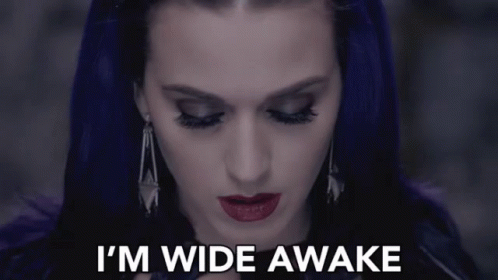 a woman with purple hair says " i 'm wide awake " in white letters