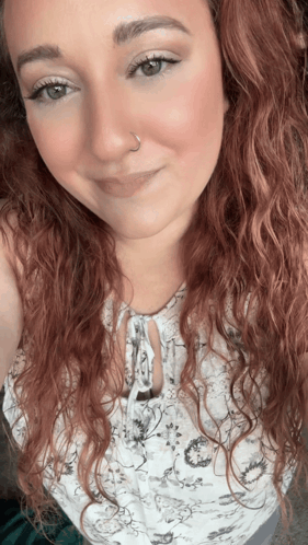 A Woman With Red Curly Hair And A Nose Ring GIF