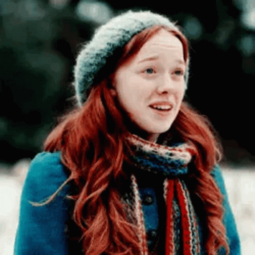 A Woman With Red Hair And A Scarf Is Wearing A Hat And Scarf . GIF