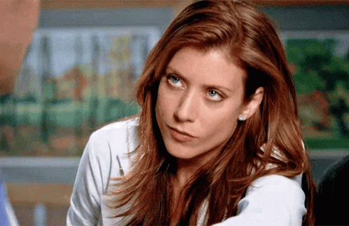 A Woman With Red Hair And Blue Eyes Is Looking At The Camera GIF