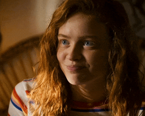 A Woman With Red Hair And Blue Eyes Is Smiling For The Camera GIF