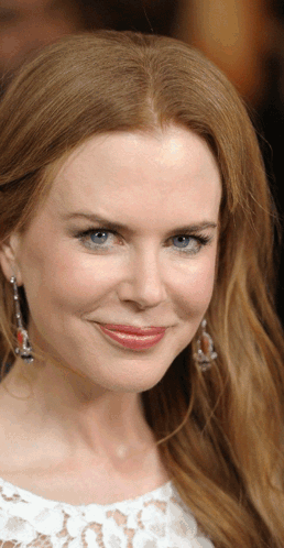 A Woman With Red Hair And Blue Eyes Is Smiling GIF