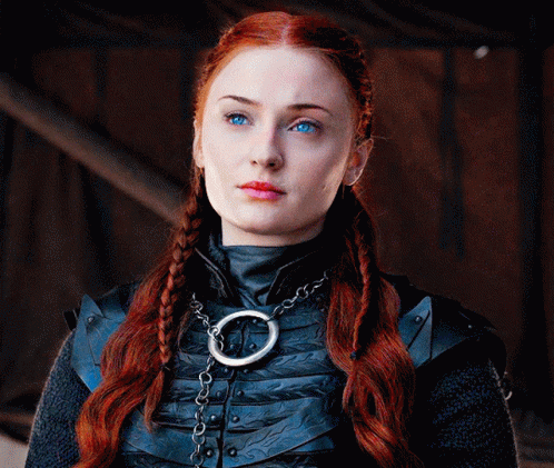 A Woman With Red Hair And Blue Eyes Is Wearing A Necklace GIF