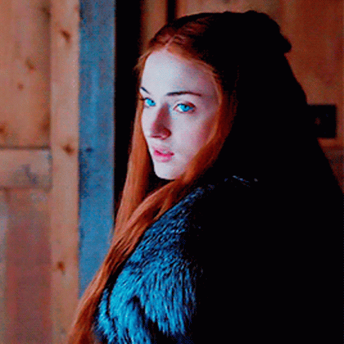 A Woman With Red Hair And Blue Eyes Wearing A Blue Fur Coat GIF